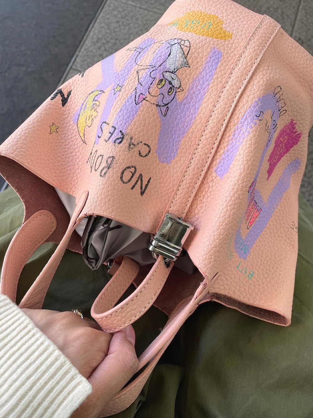 グリーン系のモッズコート、ピンク系のバッグ、ホワイト系のニット/セーターを着用したレディースの秋コーディネートの5枚目の写真