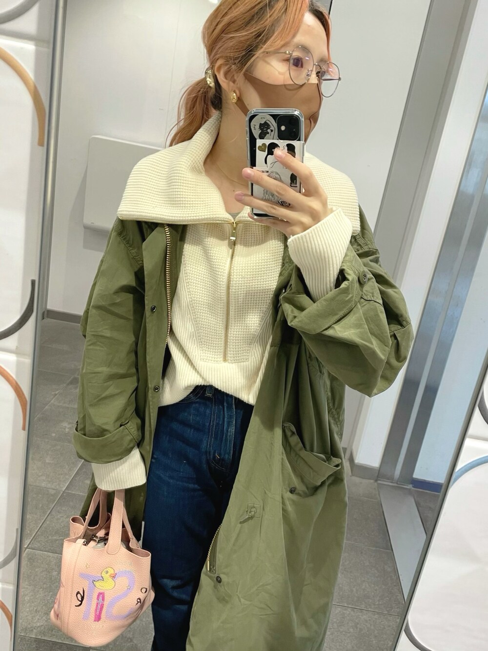 グリーン系のモッズコート、ピンク系のバッグ、ホワイト系のニット/セーターを着用したレディースの秋コーディネートの2枚目の写真