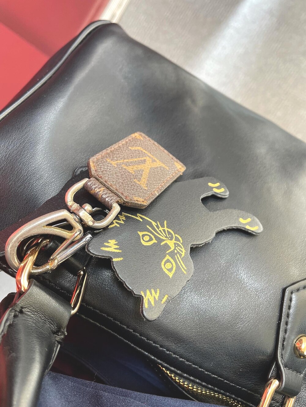 ブルー系のデニムパンツ、ブラック系のローファー、ブラック系のボストンバッグを着用したレディースの春コーディネートの3枚目の写真