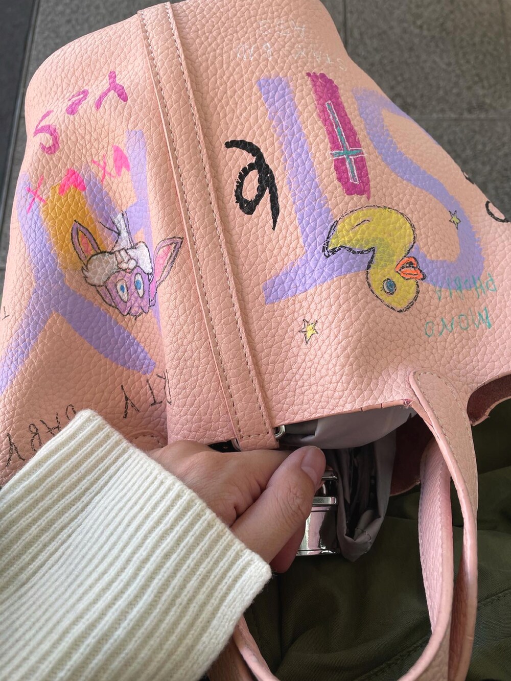 グリーン系のモッズコート、ピンク系のバッグ、ホワイト系のニット/セーターを着用したレディースの秋コーディネートの4枚目の写真