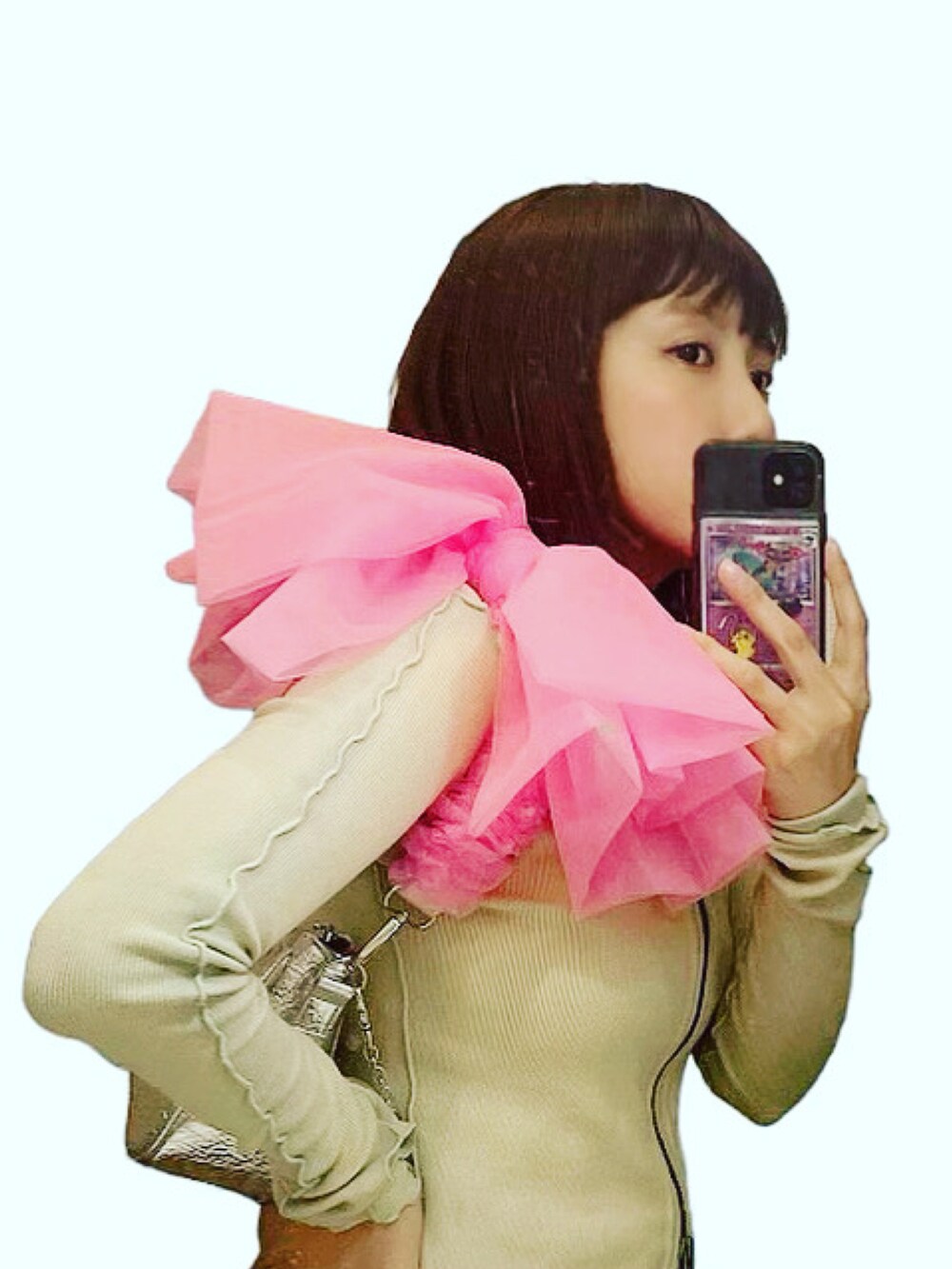 シルバー系のハンドバッグ、ベージュ系のTシャツ/カットソー、ブルー系のデニムパンツを着用したレディースの秋コーディネートの2枚目の写真