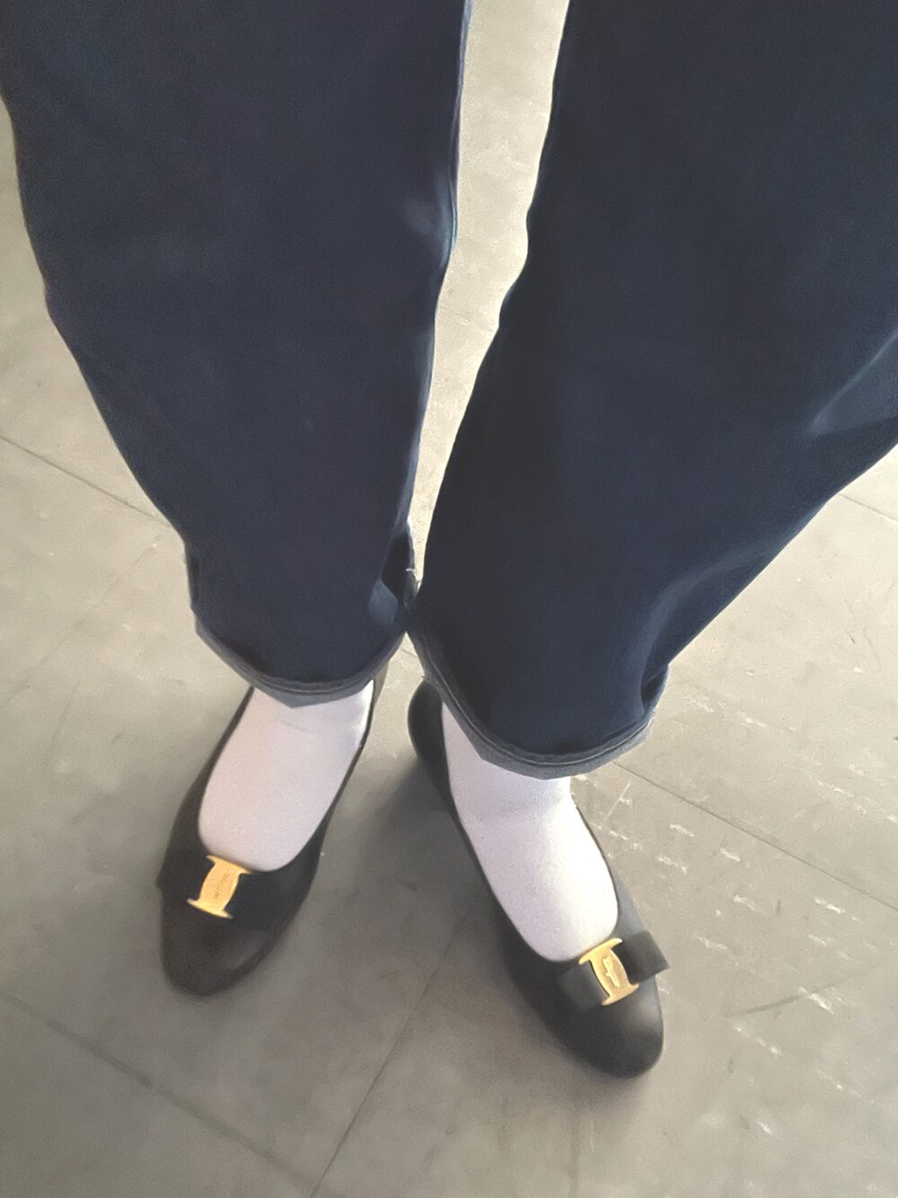 レッド系のニット/セーター、ブルー系のダウンジャケット/コート、ブルー系のデニムパンツを着用したレディースの春コーディネートの2枚目の写真