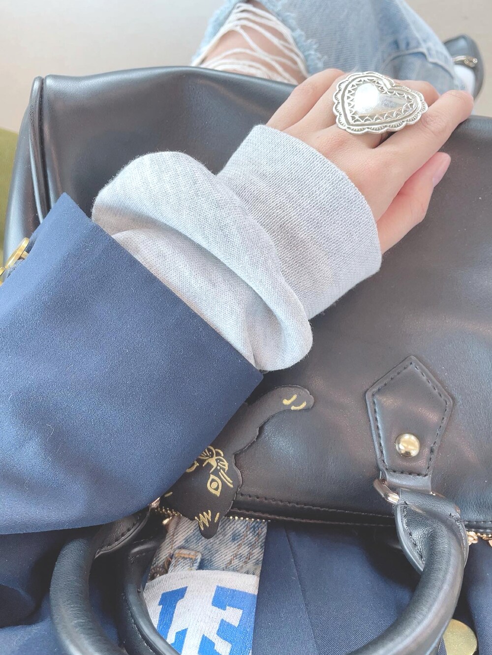 ブルー系のデニムパンツ、ブラック系のローファー、ブラック系のボストンバッグを着用したレディースの春コーディネートの2枚目の写真