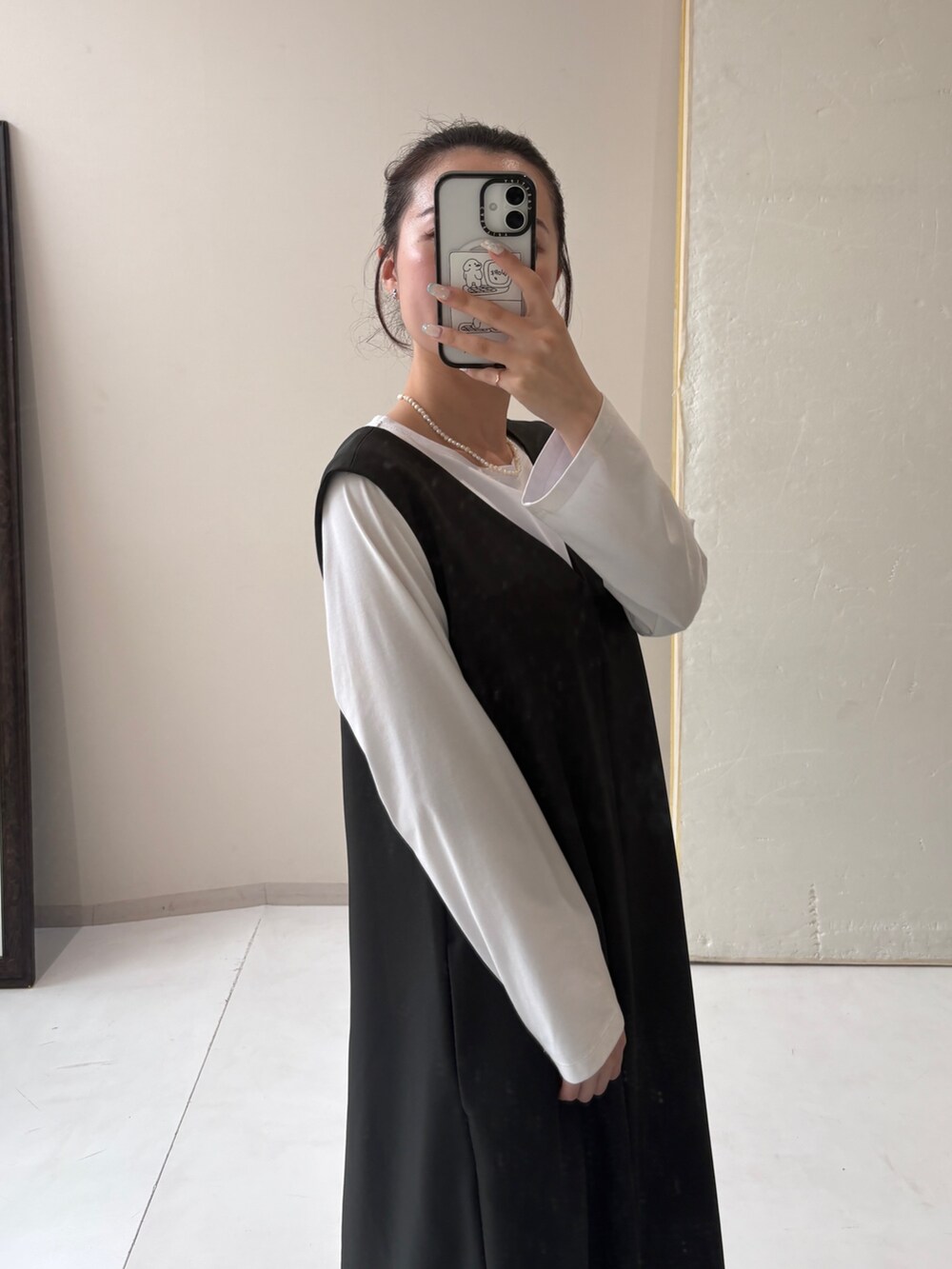 ホワイト系のTシャツ/カットソー、グレー系のジャンパースカートを着用したレディースの秋コーディネートの3枚目の写真
