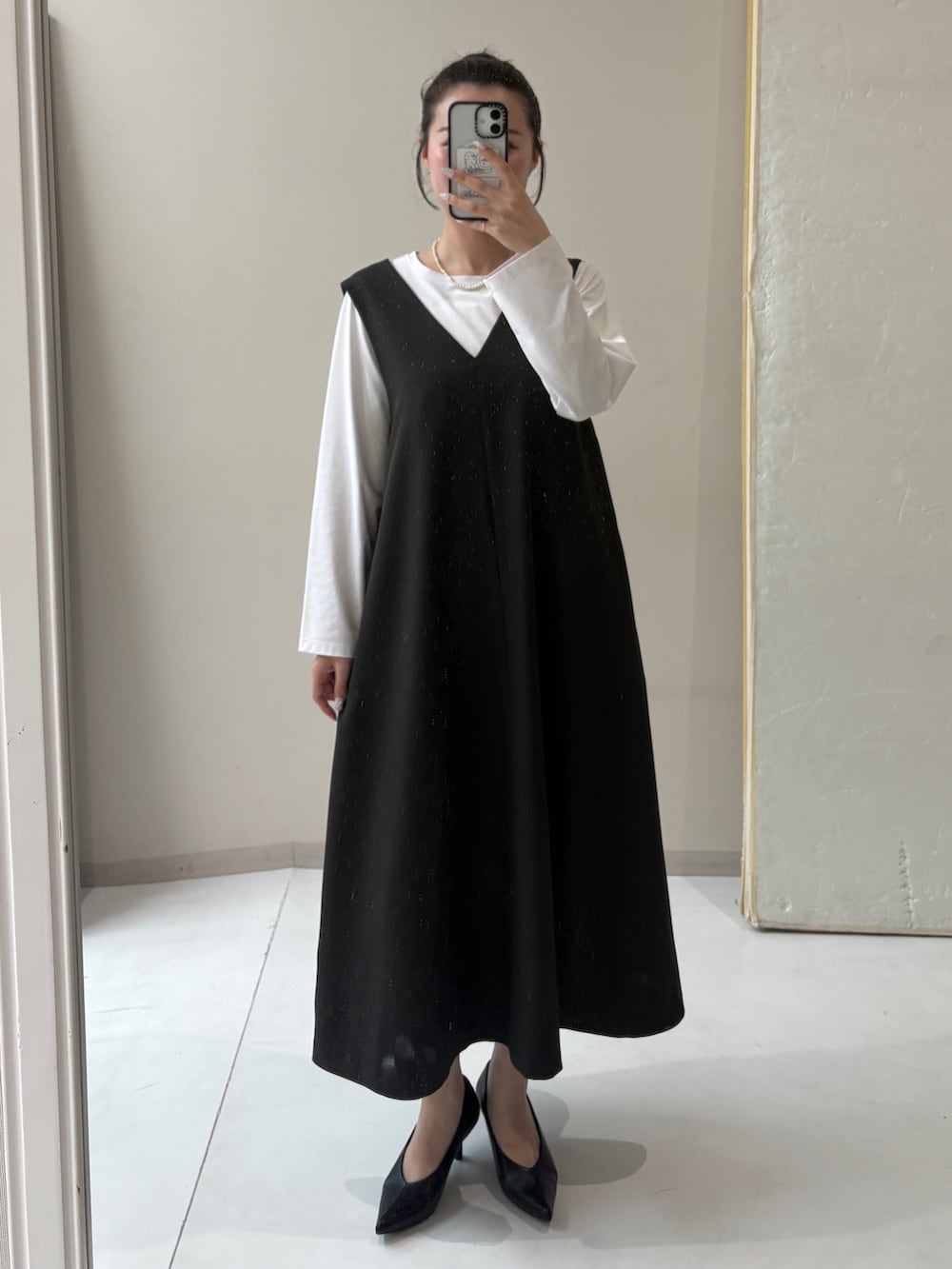 ホワイト系のTシャツ/カットソー、グレー系のジャンパースカートを着用したレディースの秋コーディネートの2枚目の写真