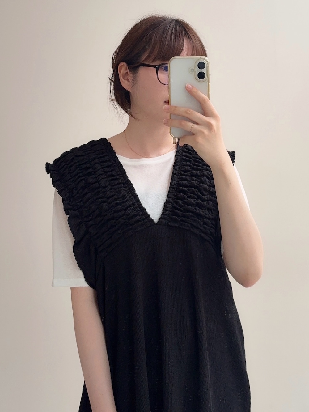 ブラック系のジャンパースカート、ブルー系のデニムパンツ、ホワイト系のTシャツ/カットソーを着用したレディースの春コーディネートの5枚目の写真