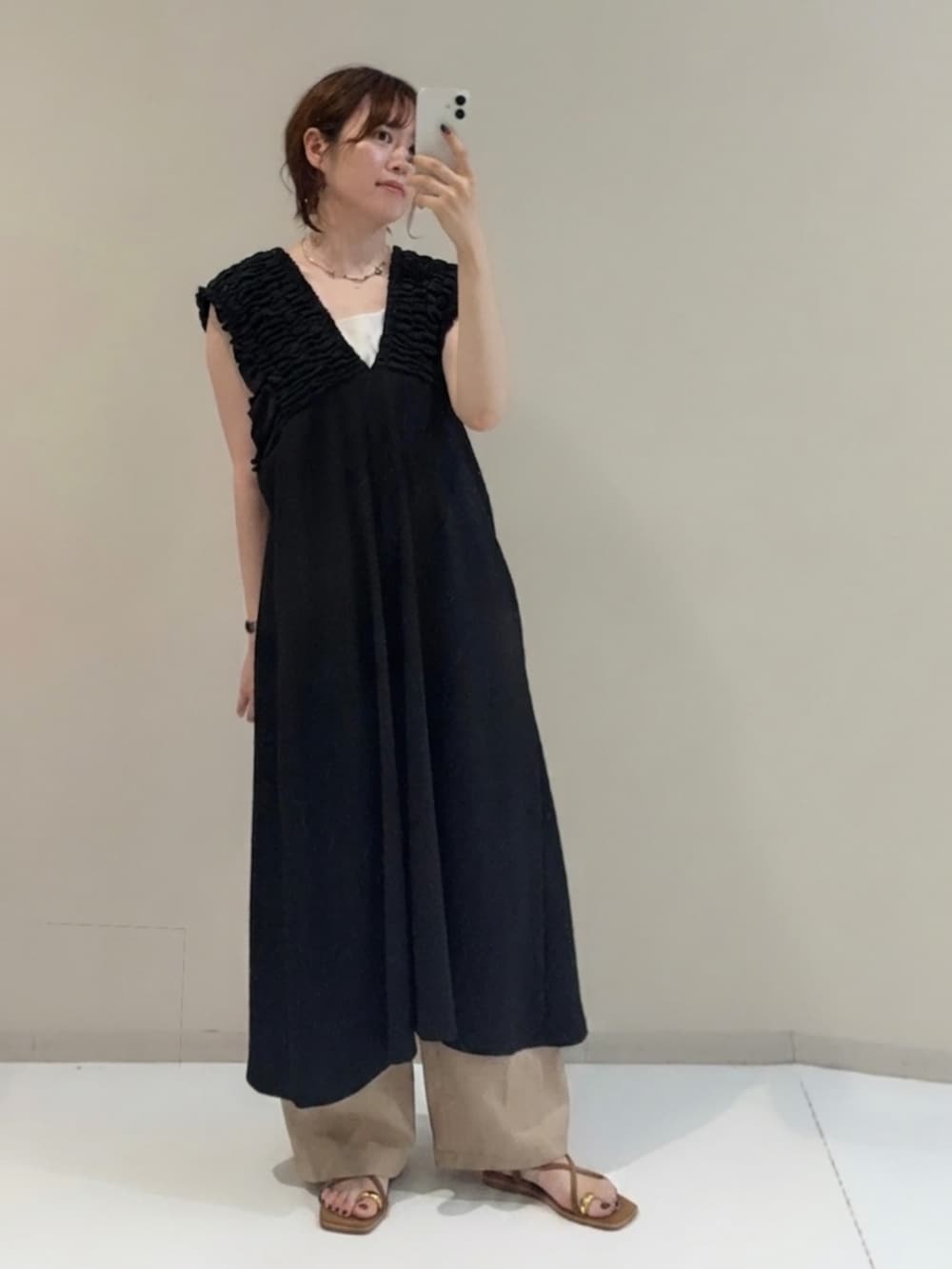 ベージュ系のパンツ、ブラック系のつなぎ/オールインワン、ホワイト系のタンクトップを着用したレディースの夏コーディネートの2枚目の写真