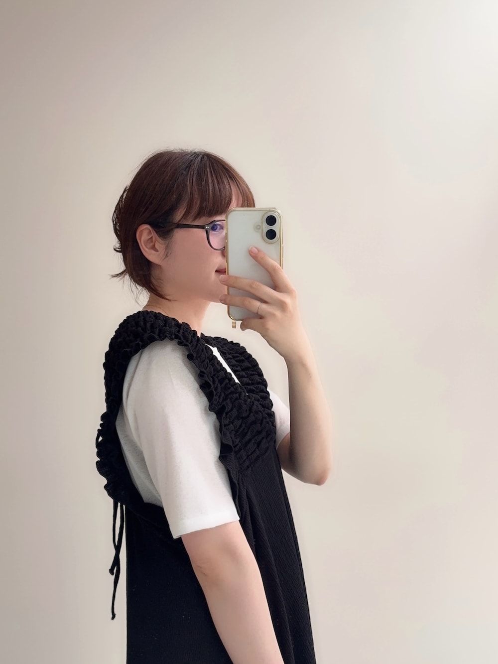 ブラック系のジャンパースカート、ブルー系のデニムパンツ、ホワイト系のTシャツ/カットソーを着用したレディースの春コーディネートの4枚目の写真