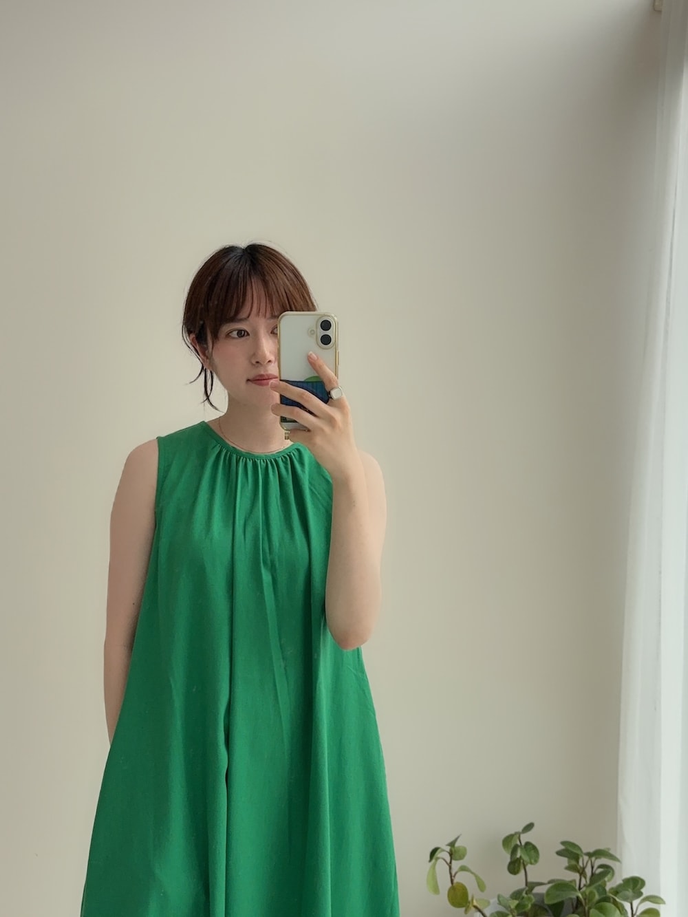 グリーン系のワンピース、ベージュ系のパンツを着用したレディースの夏コーディネートの2枚目の写真