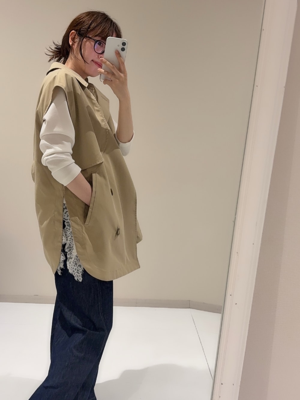 ブルー系のデニムパンツ、ホワイト系のTシャツ/カットソー、ベージュ系のベストを着用したレディースの秋コーディネートの2枚目の写真