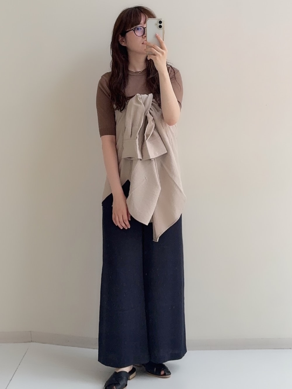 ベージュ系のシャツ/ブラウス、ブラウン系のニット/セーター、ブルー系のその他パンツを着用したレディースの春コーディネートの3枚目の写真