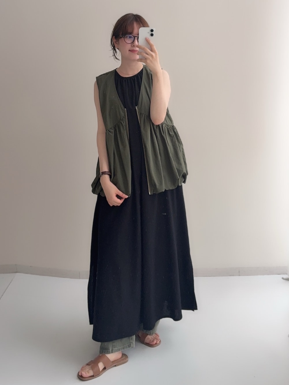 ブラック系のワンピース、ブラウン系のベスト、ベージュ系のデニムパンツを着用したレディースの夏コーディネートの3枚目の写真