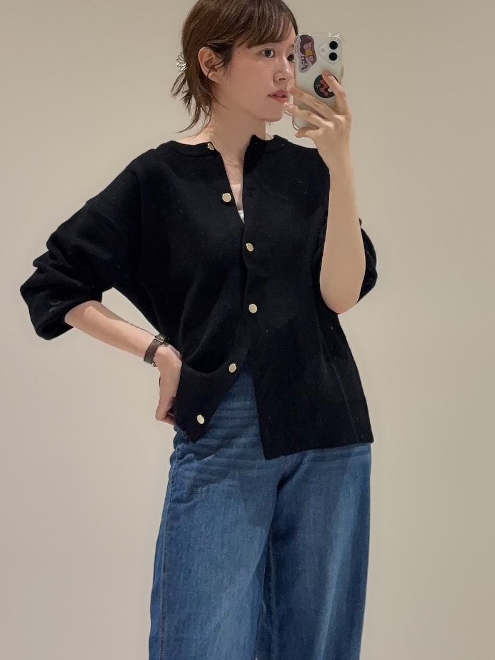 ブルー系のデニムパンツ、ブラック系のカーディガン/ボレロを着用したレディースの秋コーディネートの2枚目の写真