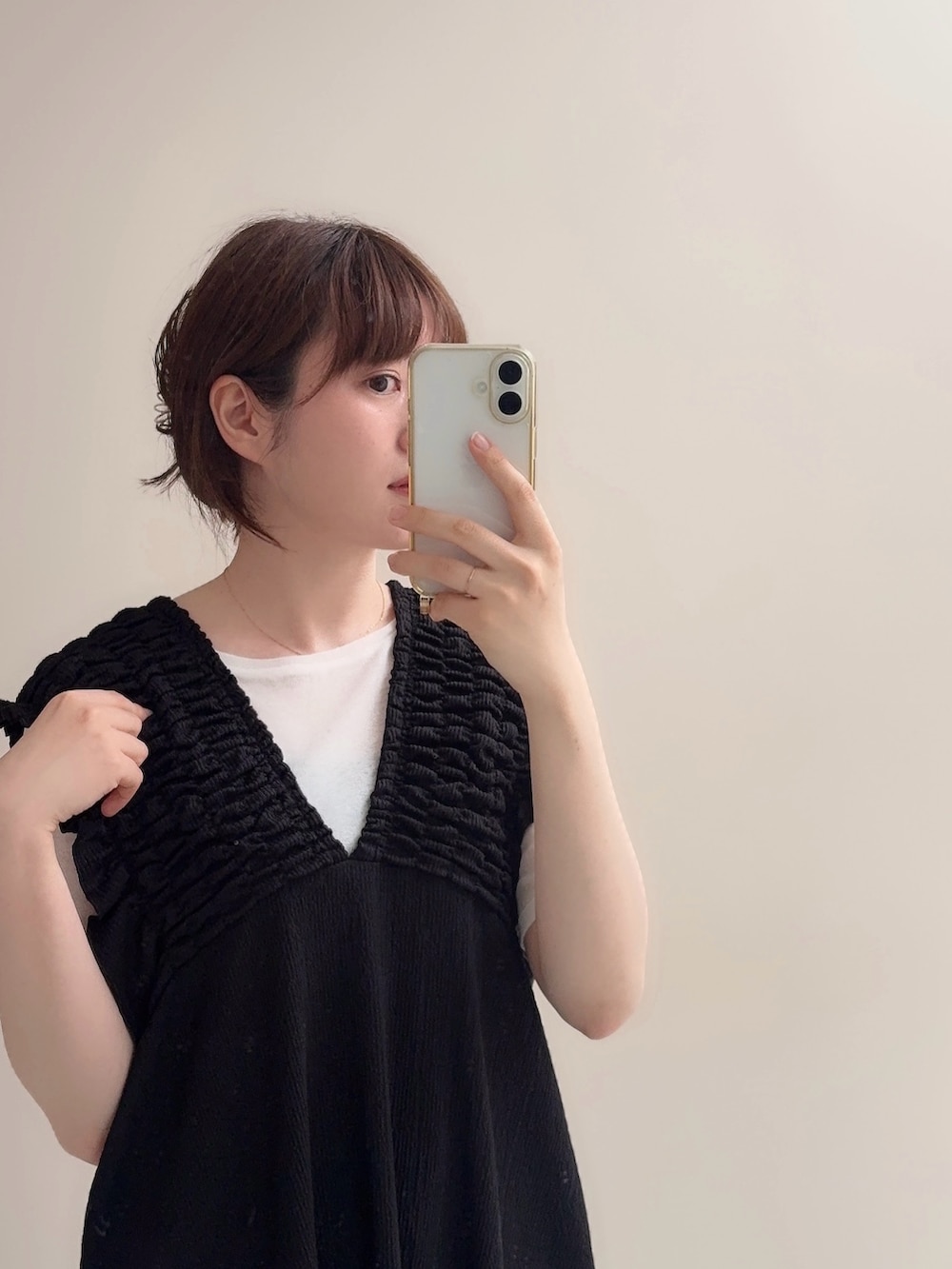 ブラック系のジャンパースカート、ブルー系のデニムパンツ、ホワイト系のTシャツ/カットソーを着用したレディースの春コーディネートの7枚目の写真