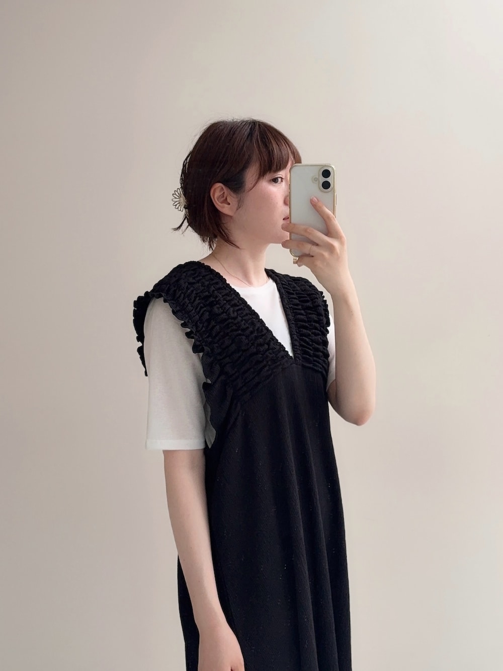 ブラック系のジャンパースカート、ブルー系のデニムパンツ、ホワイト系のTシャツ/カットソーを着用したレディースの春コーディネートの2枚目の写真