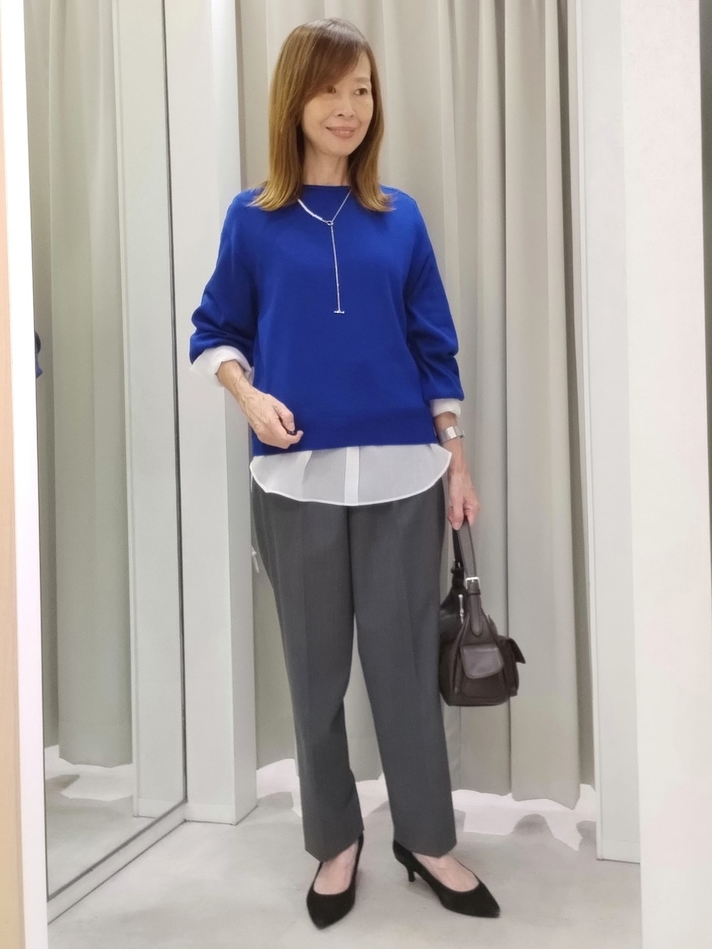 ブルー系のニット/セーター、ホワイト系のTシャツ/カットソー、グレー系のその他パンツを着用したレディースの秋コーディネートの3枚目の写真