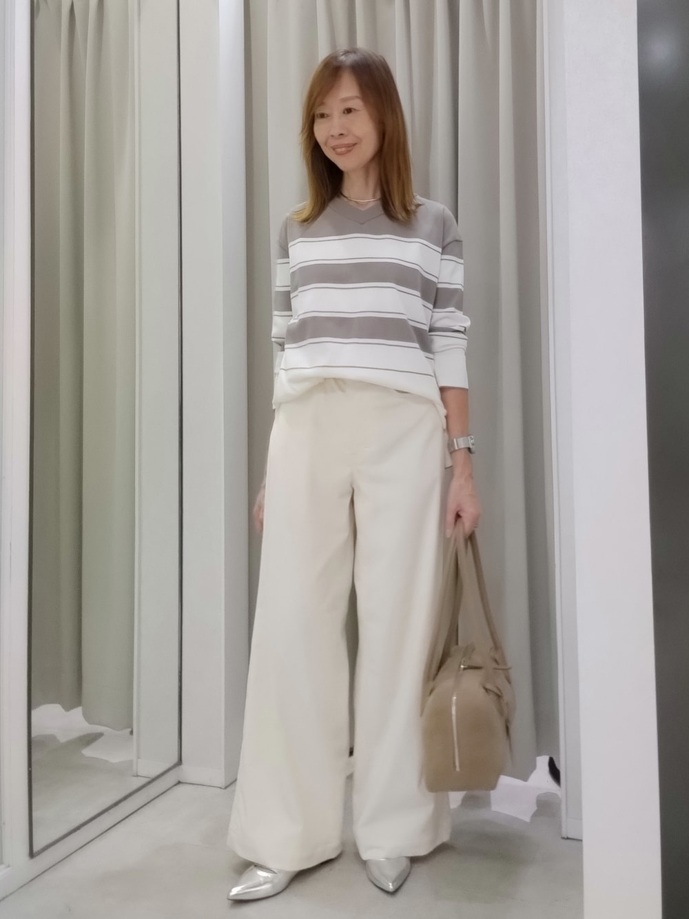 ブラウン系のニット/セーター、ホワイト系のその他パンツ、グリーン系のブルゾンを着用したレディースの秋コーディネートの5枚目の写真