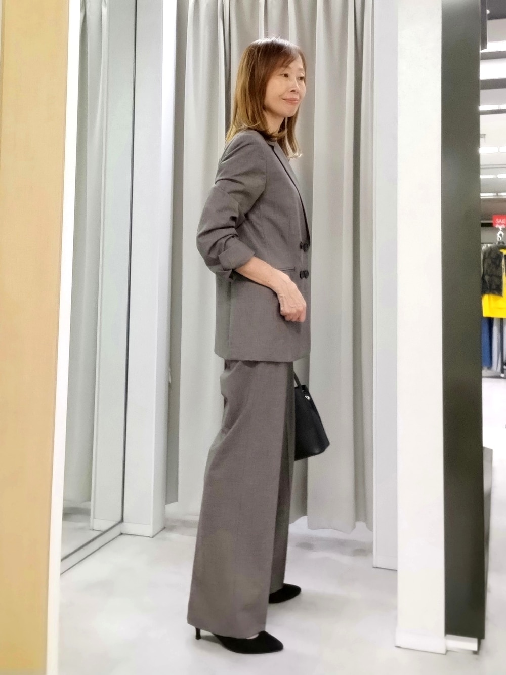 ベージュ系のテーラードジャケット、ベージュ系のその他パンツ、ホワイト系のタンクトップを着用したレディースの秋コーディネートの3枚目の写真