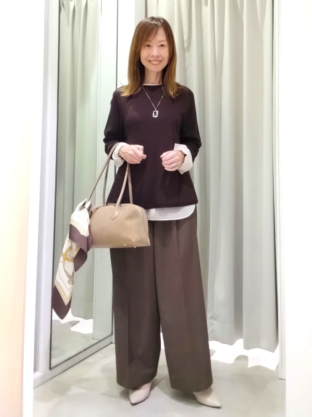 ブラウン系のニット/セーター、ベージュ系のTシャツ/カットソー、ブラウン系のその他パンツを着用したレディースの秋コーディネートの2枚目の写真
