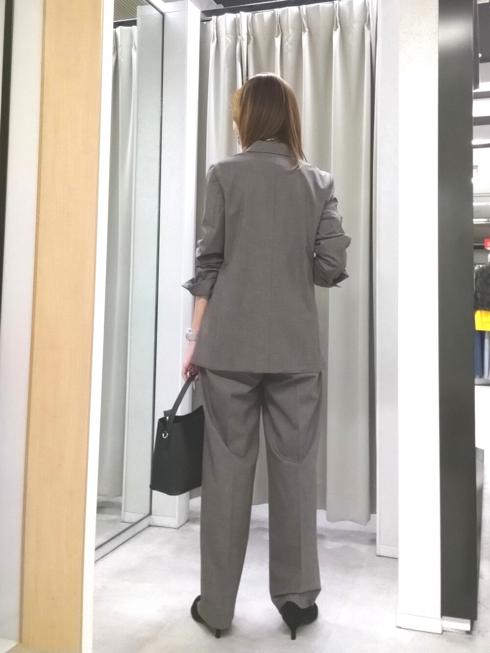 ベージュ系のテーラードジャケット、ベージュ系のその他パンツ、ホワイト系のタンクトップを着用したレディースの秋コーディネートの4枚目の写真