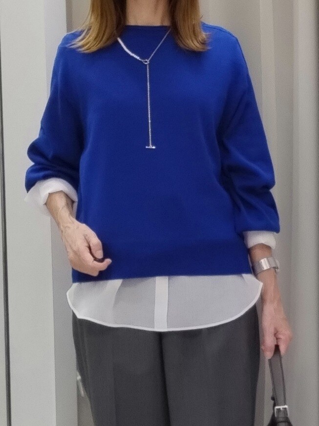 ブルー系のニット/セーター、ホワイト系のTシャツ/カットソー、グレー系のその他パンツを着用したレディースの秋コーディネートの4枚目の写真
