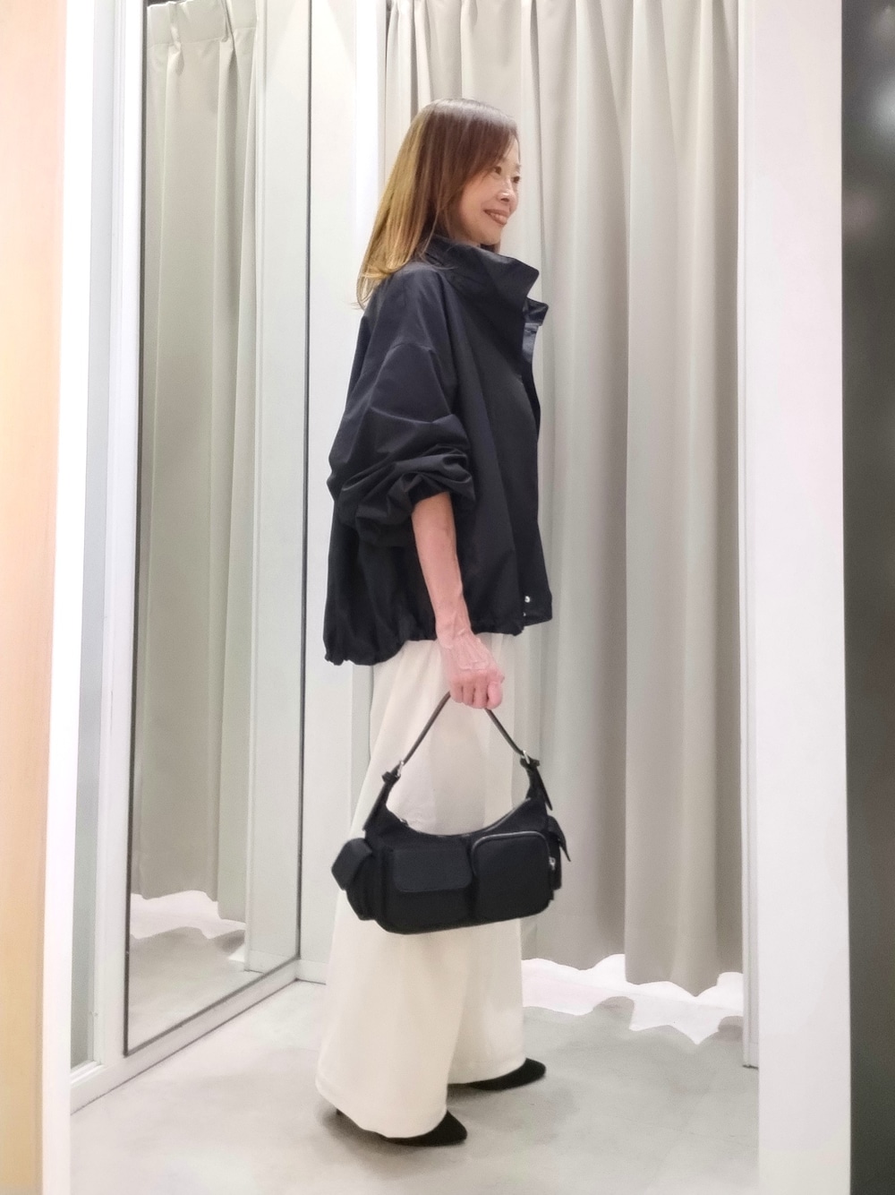 ブラック系のブルゾン、グレー系のニット/セーター、ホワイト系のその他パンツを着用したレディースの秋コーディネートの6枚目の写真