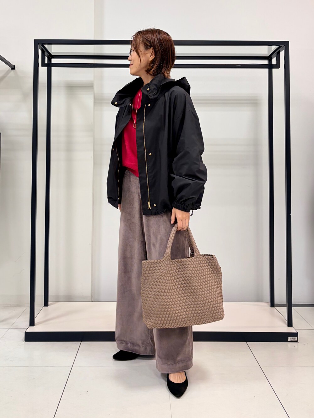 ピンク系のニット/セーター、ブラウン系のその他パンツ、ブラック系のブルゾンを着用したレディースの秋コーディネートの9枚目の写真