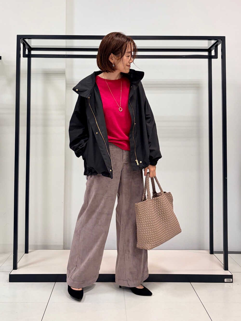 ピンク系のニット/セーター、ブラウン系のその他パンツ、ブラック系のブルゾンを着用したレディースの秋コーディネートの2枚目の写真