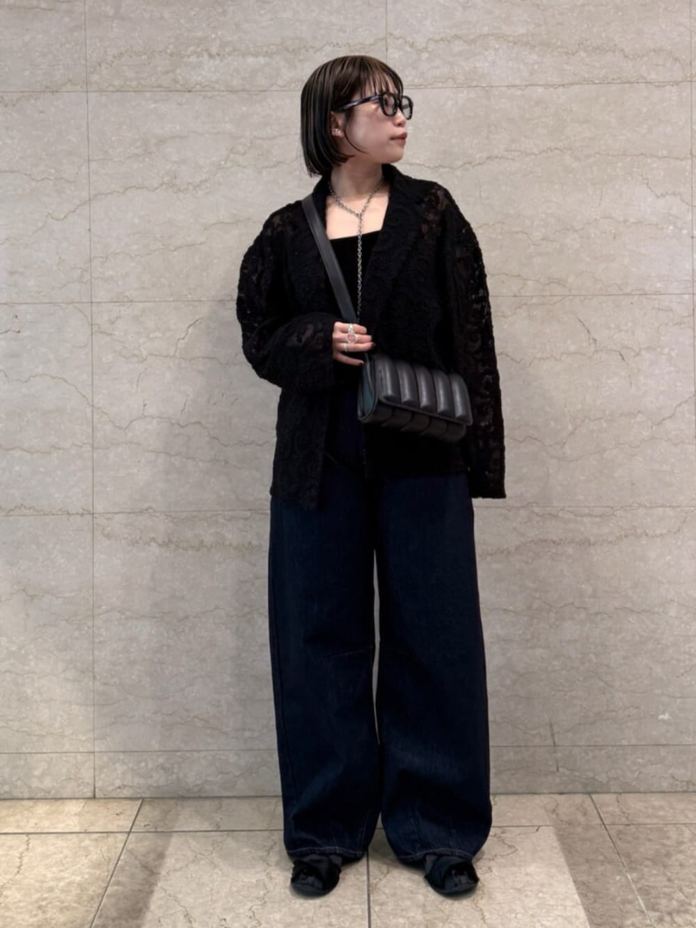 ブルー系のデニムパンツ、ブラック系のテーラードジャケットを着用したレディースの春コーディネートの2枚目の写真