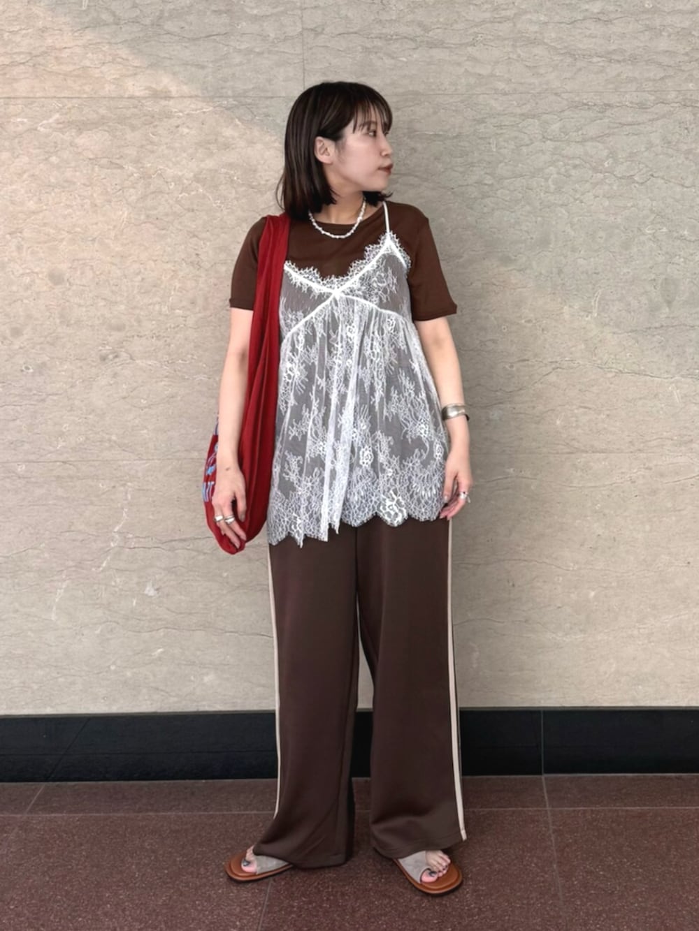 ホワイト系のキャミソール、ブラウン系のその他パンツ、レッド系のトートバッグを着用したレディースの夏コーディネートの3枚目の写真