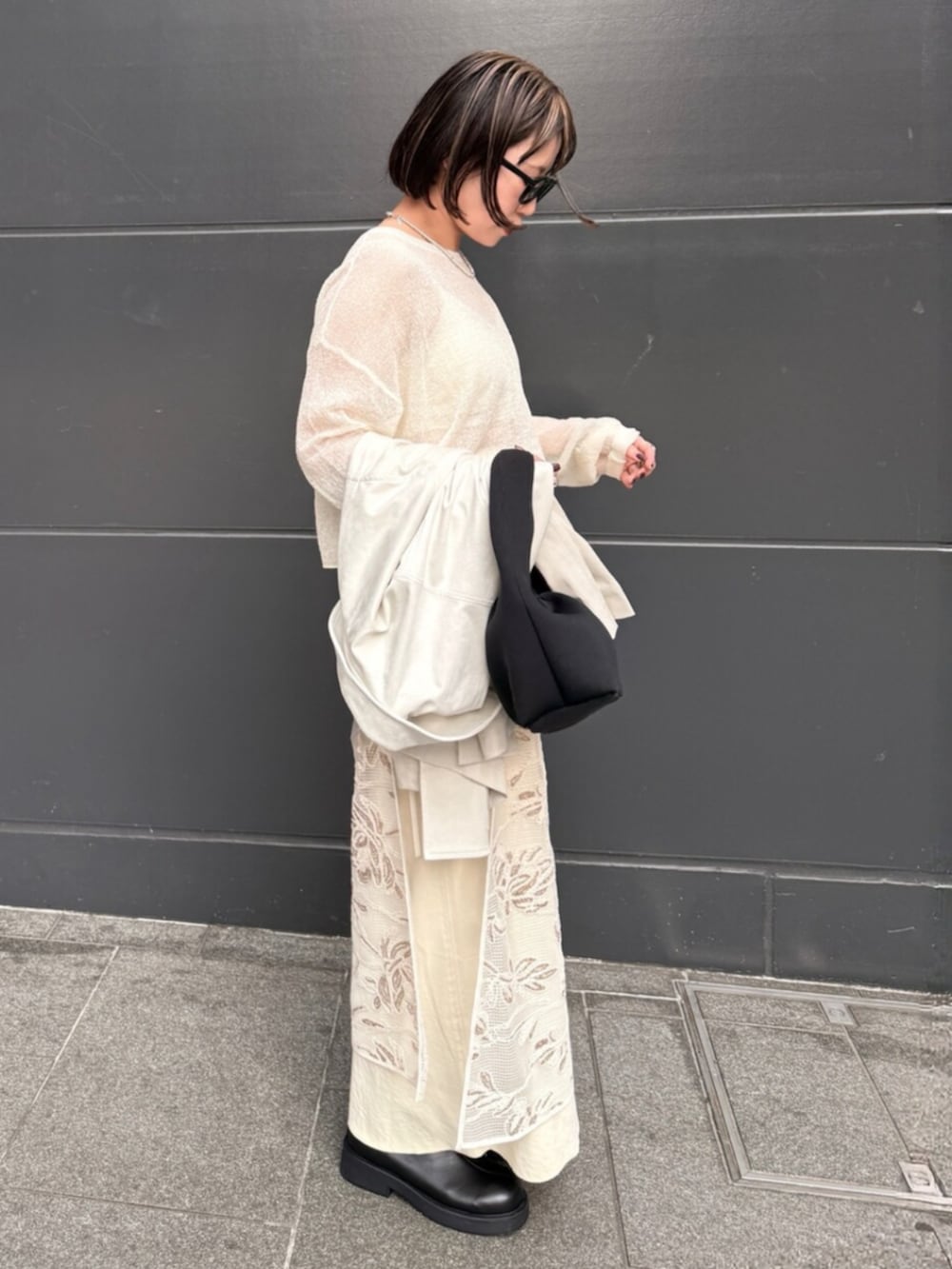 ホワイト系のスカート、ホワイト系のニット/セーター、イエロー系のスカートを着用したレディースの春コーディネートの4枚目の写真