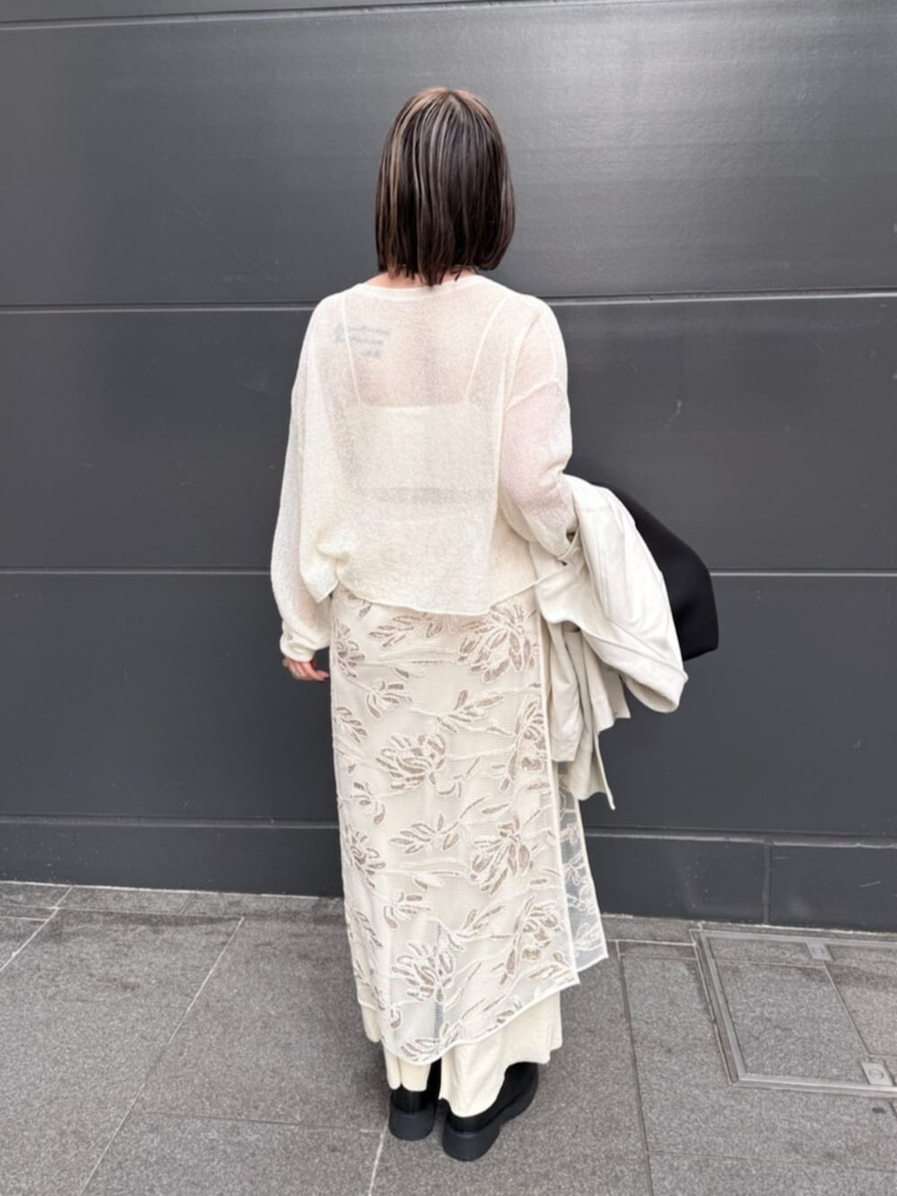 ホワイト系のスカート、ホワイト系のニット/セーター、イエロー系のスカートを着用したレディースの春コーディネートの6枚目の写真