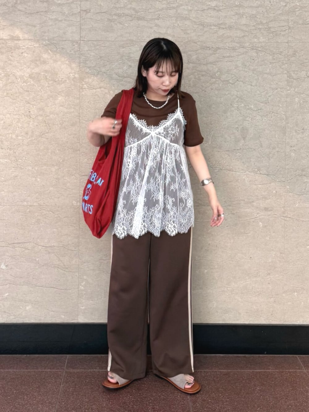 ホワイト系のキャミソール、ブラウン系のその他パンツ、レッド系のトートバッグを着用したレディースの夏コーディネートの5枚目の写真