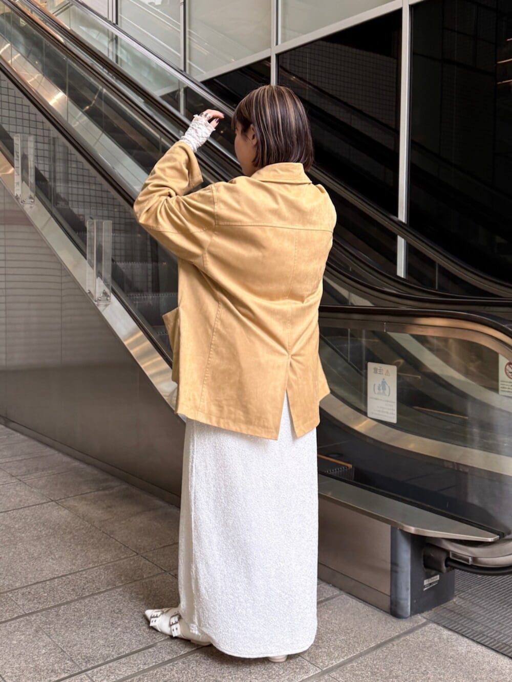 イエロー系のテーラードジャケット、ホワイト系のTシャツ/カットソー、ホワイト系のスカートを着用したレディースの春コーディネートの4枚目の写真