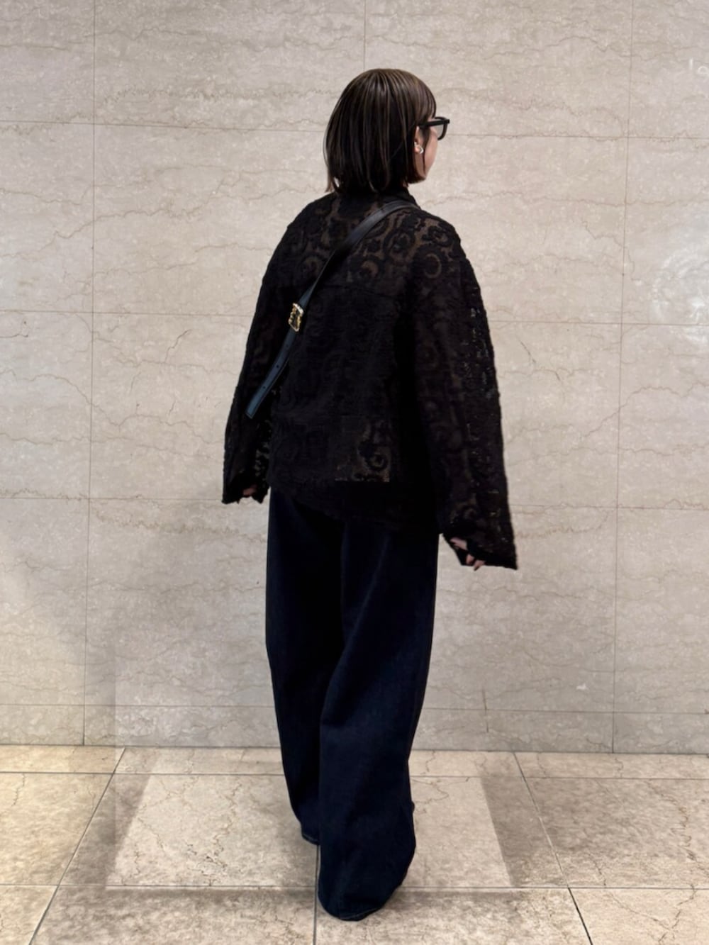 ブルー系のデニムパンツ、ブラック系のテーラードジャケットを着用したレディースの春コーディネートの3枚目の写真