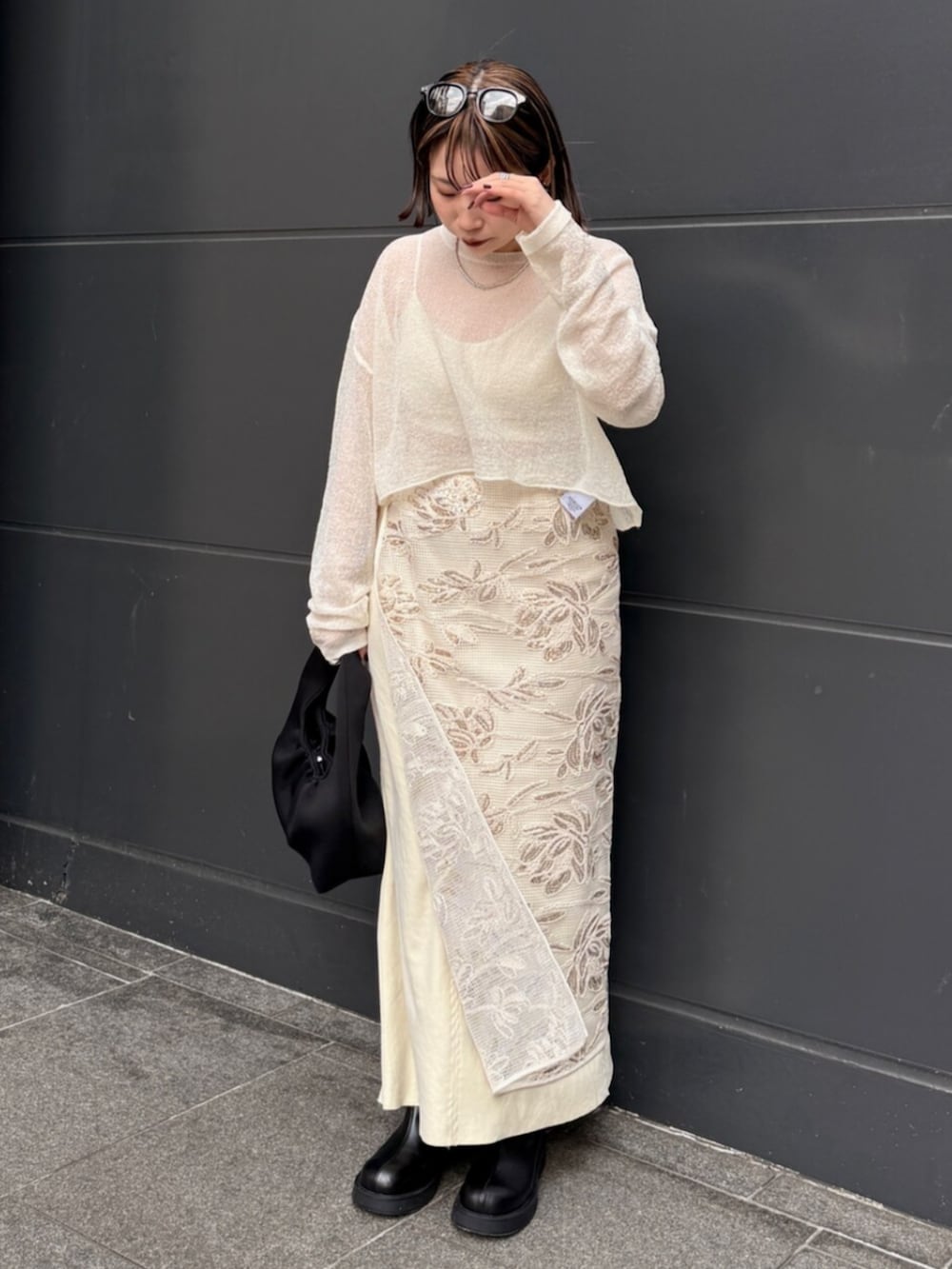 ホワイト系のスカート、ホワイト系のニット/セーター、イエロー系のスカートを着用したレディースの春コーディネートの2枚目の写真