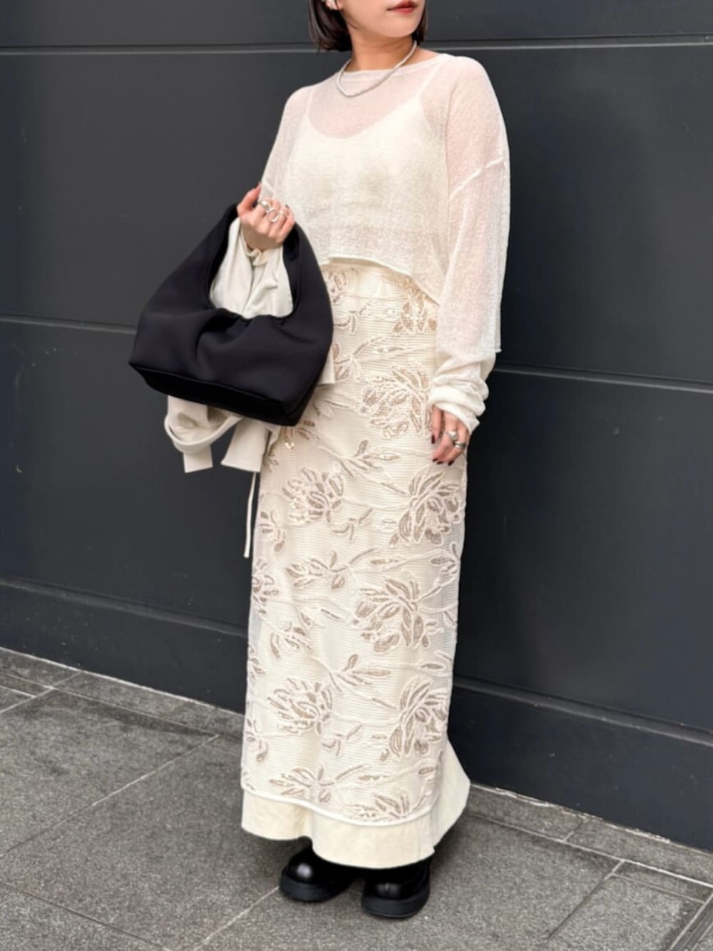 ホワイト系のスカート、ホワイト系のニット/セーター、イエロー系のスカートを着用したレディースの春コーディネートの5枚目の写真