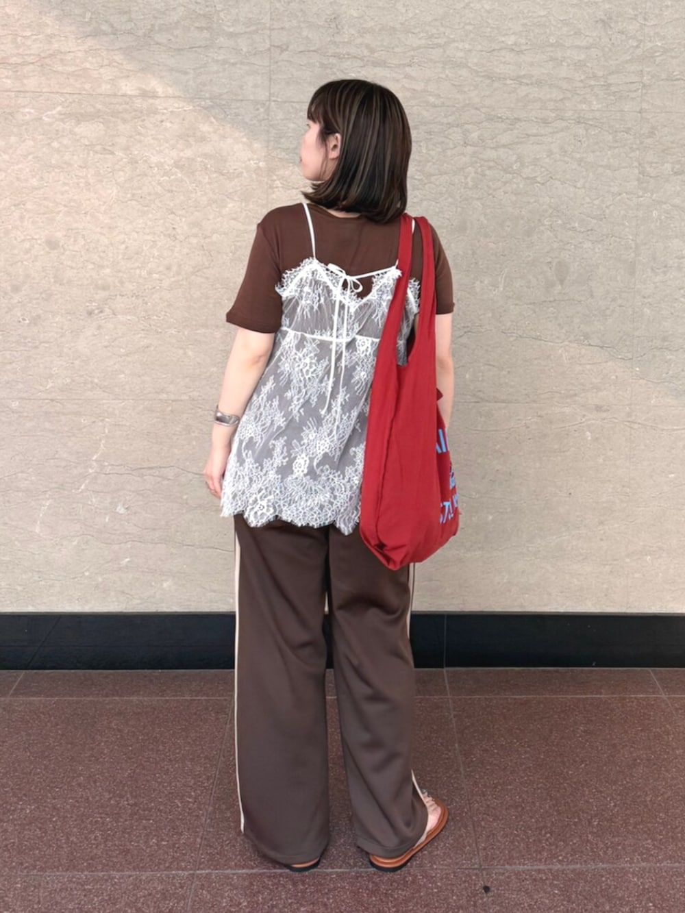 ホワイト系のキャミソール、ブラウン系のその他パンツ、レッド系のトートバッグを着用したレディースの夏コーディネートの2枚目の写真