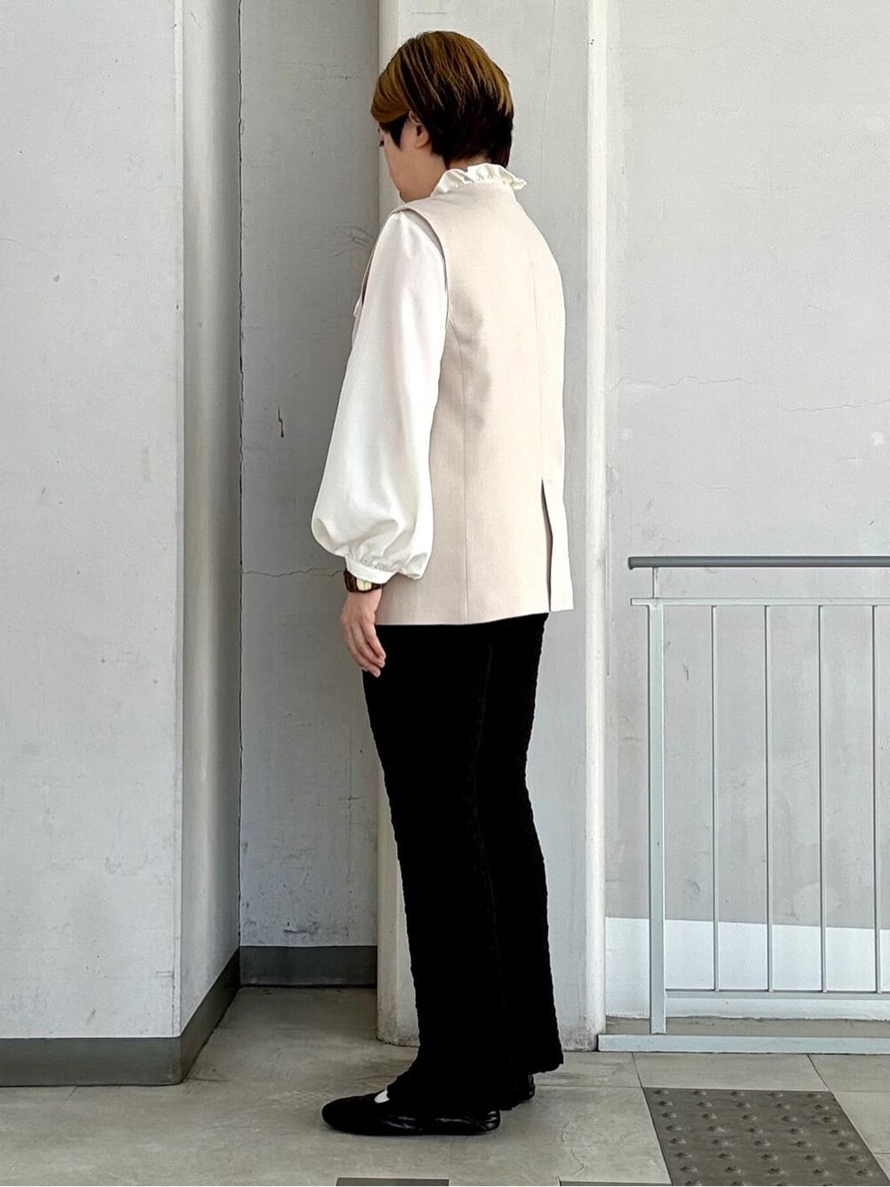 ベージュ系のベスト、ホワイト系のシャツ/ブラウス、ブラック系のその他パンツを着用したレディースの春コーディネートの2枚目の写真