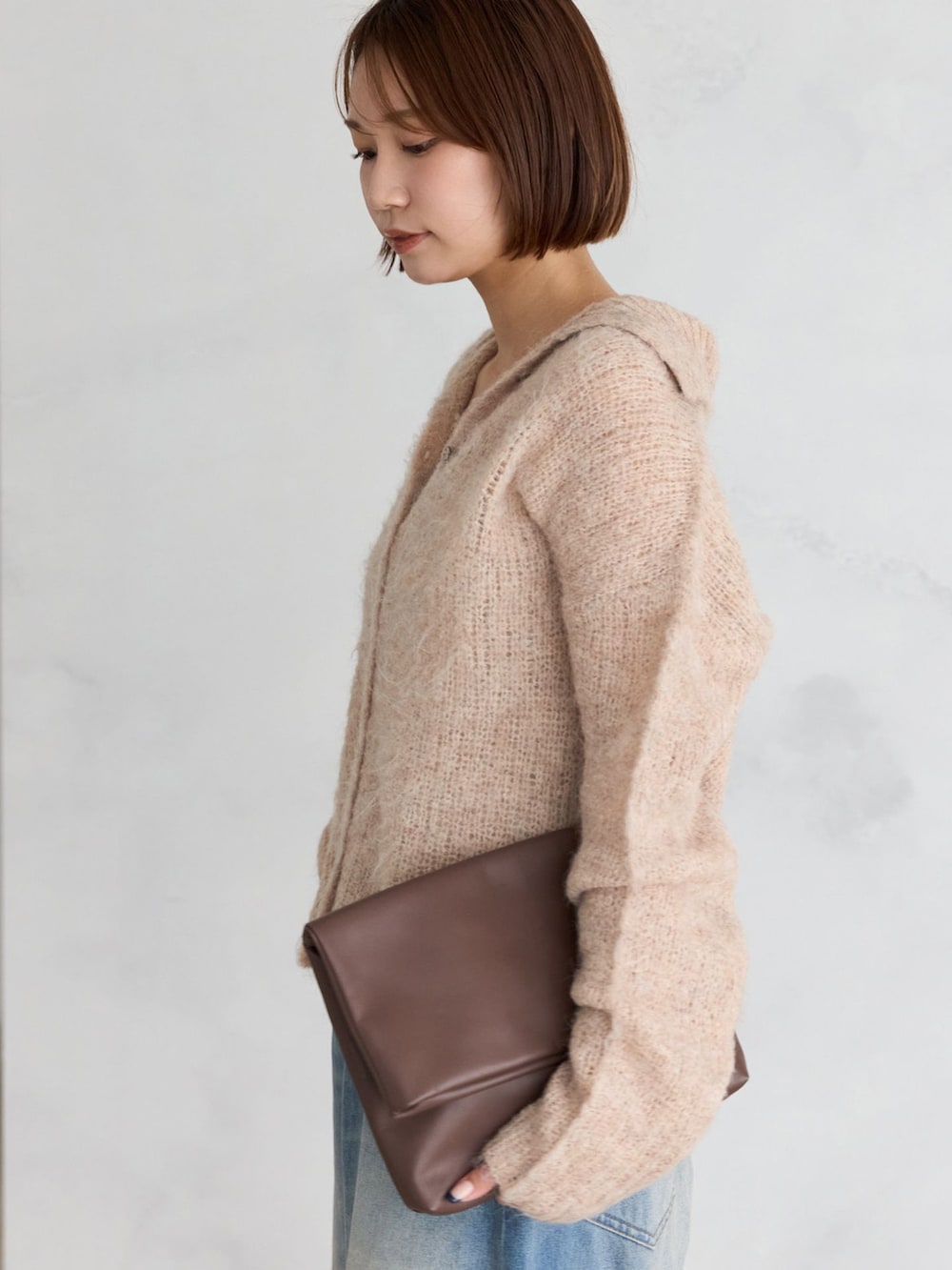 ブルー系のデニムパンツ、ピンク系のカーディガン/ボレロを着用したレディースの秋コーディネートの5枚目の写真