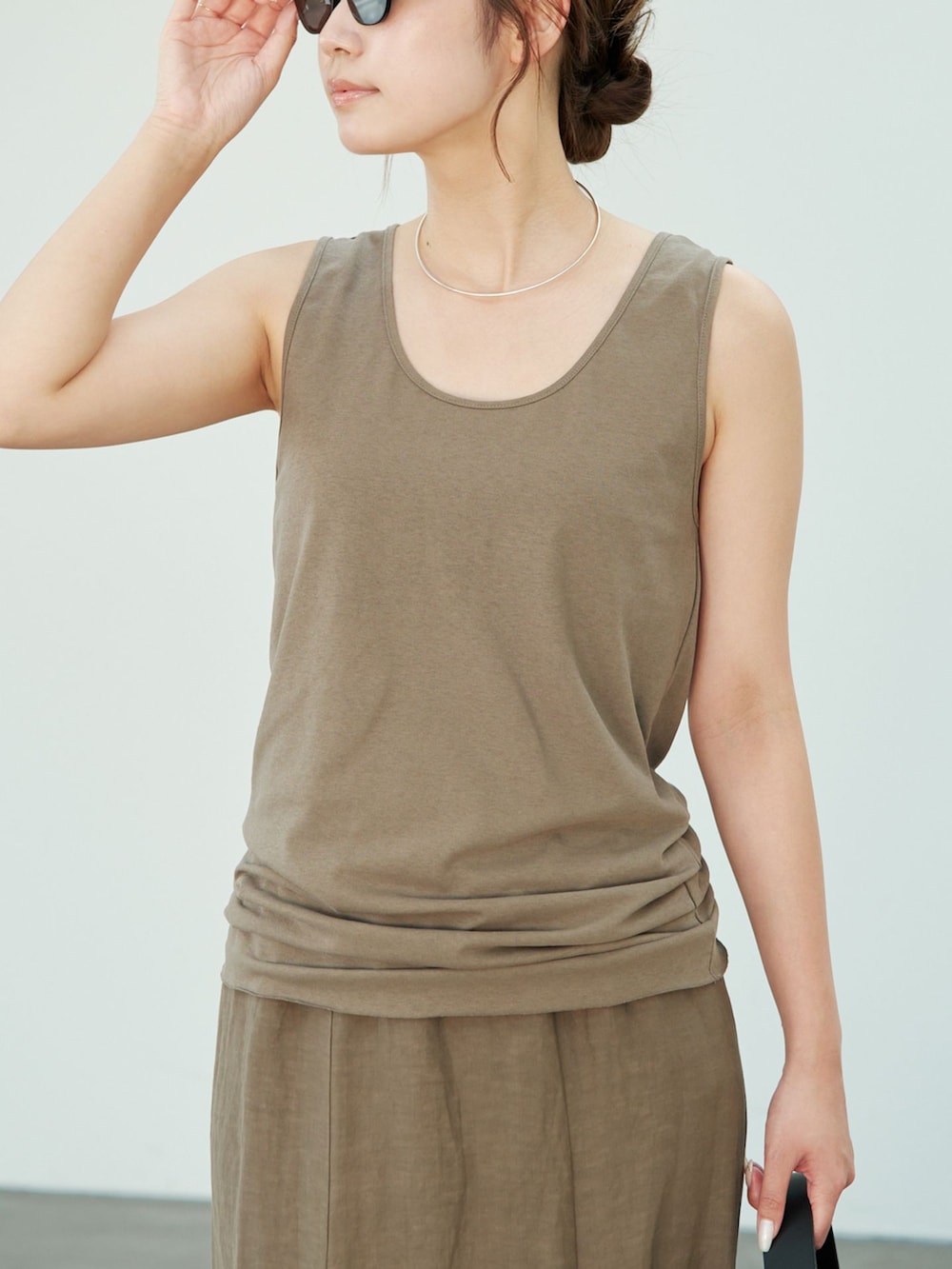 グリーン系のスカート、グリーン系のTシャツ/カットソー、ブラウン系のサンダルを着用したレディースの夏コーディネートの4枚目の写真