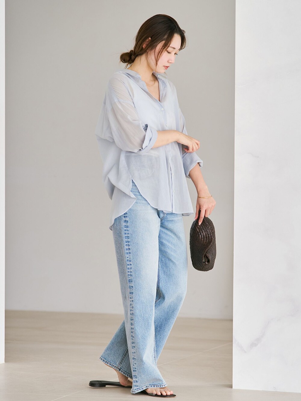 ブルー系のデニムパンツ、ブルー系のシャツ/ブラウス、ブラウン系のサンダルを着用したレディースの夏コーディネートの2枚目の写真