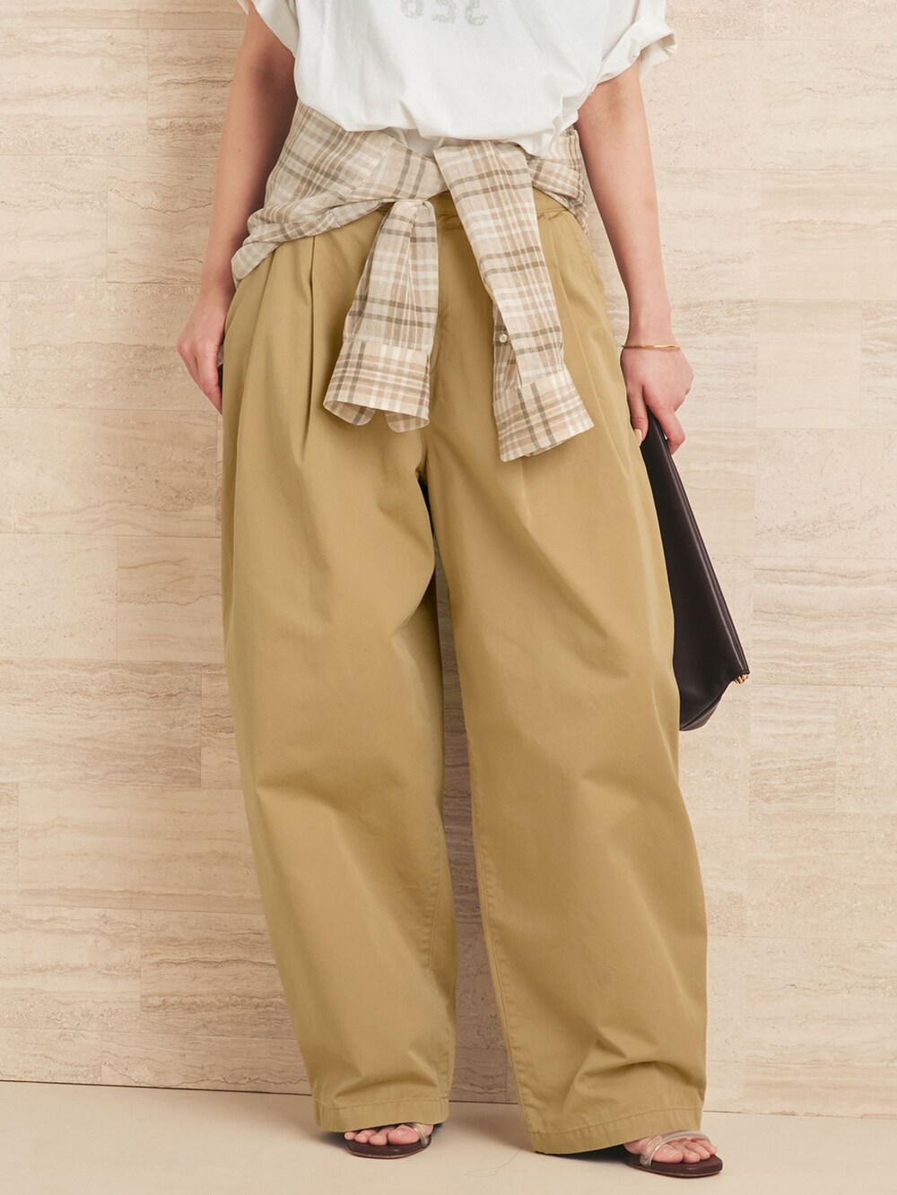 ベージュ系のチノパンツ、ベージュ系のシャツ/ブラウス、ホワイト系のクラッチバッグを着用したレディースの夏コーディネートの8枚目の写真