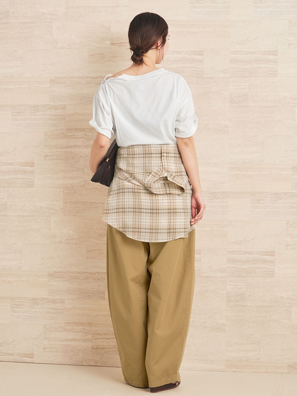 ベージュ系のチノパンツ、ベージュ系のシャツ/ブラウス、ホワイト系のクラッチバッグを着用したレディースの夏コーディネートの3枚目の写真