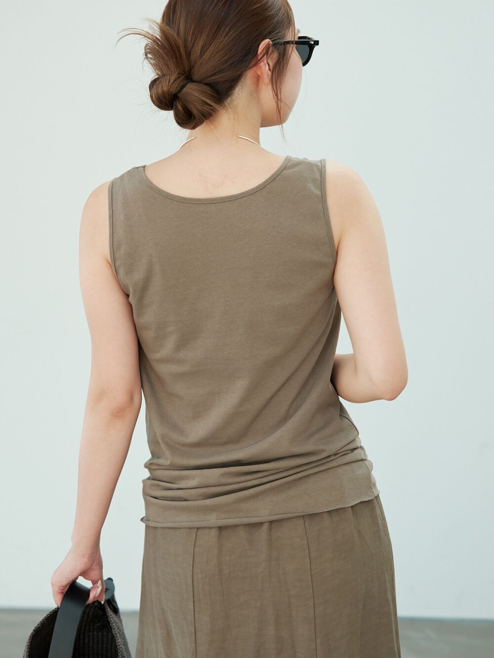 グリーン系のスカート、グリーン系のTシャツ/カットソー、ブラウン系のサンダルを着用したレディースの夏コーディネートの6枚目の写真