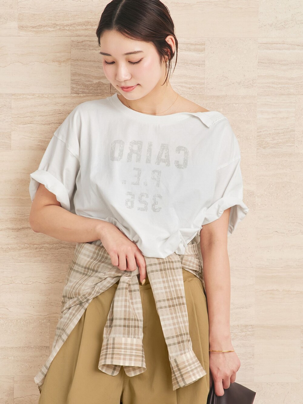 ベージュ系のチノパンツ、ベージュ系のシャツ/ブラウス、ホワイト系のクラッチバッグを着用したレディースの夏コーディネートの4枚目の写真