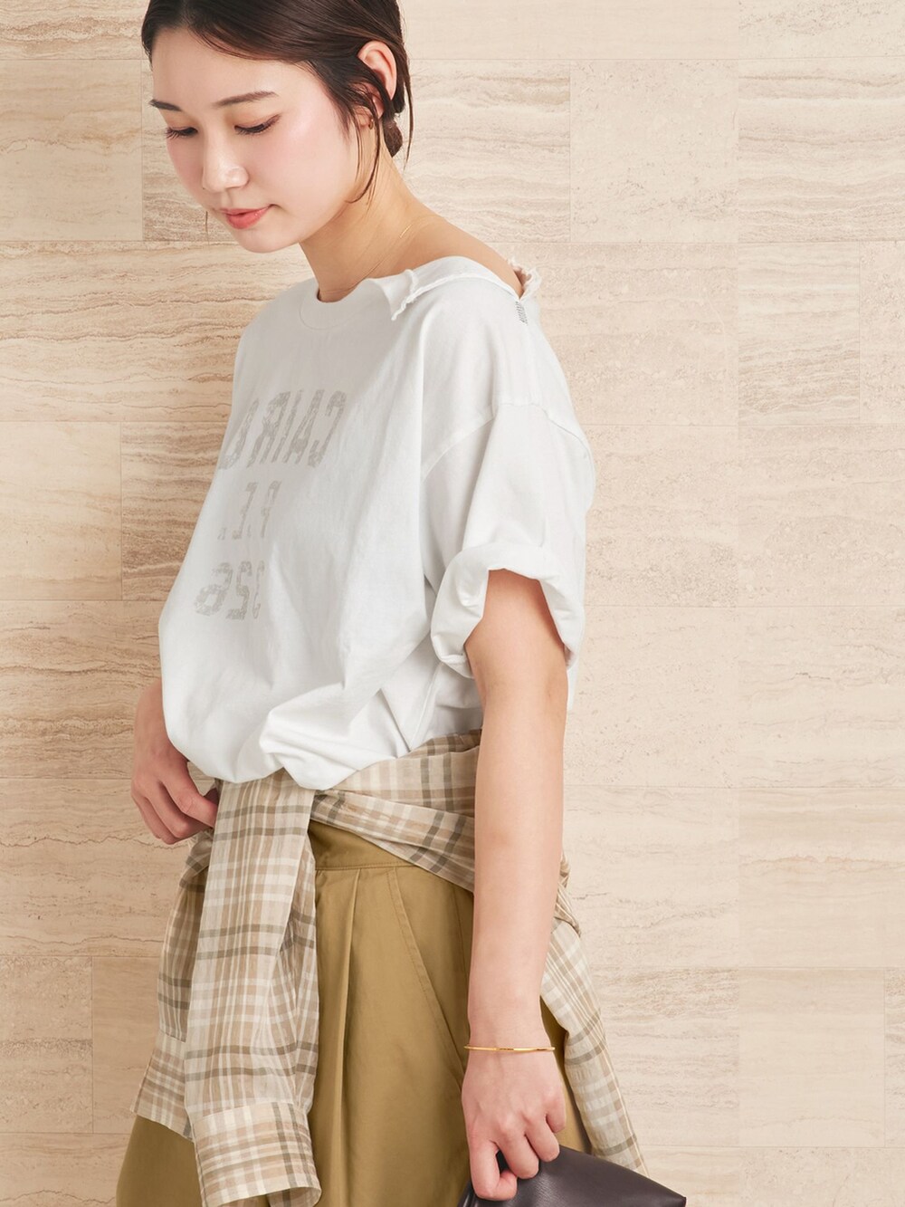 ベージュ系のチノパンツ、ベージュ系のシャツ/ブラウス、ホワイト系のクラッチバッグを着用したレディースの夏コーディネートの5枚目の写真