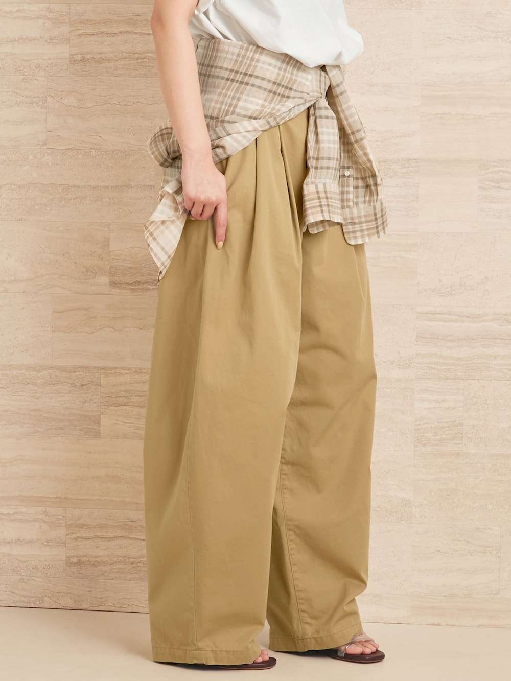 ベージュ系のチノパンツ、ベージュ系のシャツ/ブラウス、ホワイト系のクラッチバッグを着用したレディースの夏コーディネートの9枚目の写真
