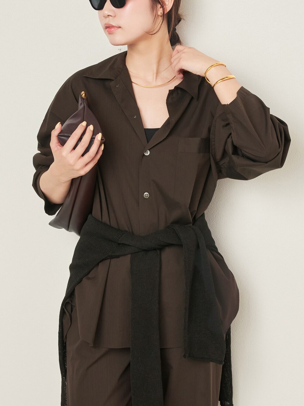 ブラウン系のその他パンツ、ブラウン系のシャツ/ブラウス、ブラウン系のクラッチバッグを着用したレディースの春コーディネートの4枚目の写真