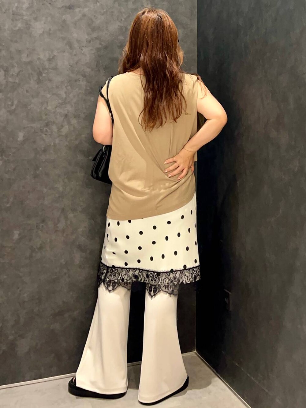 ベージュ系のTシャツ/カットソー、ブラック系のサンダル、ブラック系のショルダーバッグを着用したレディースの夏コーディネートの3枚目の写真
